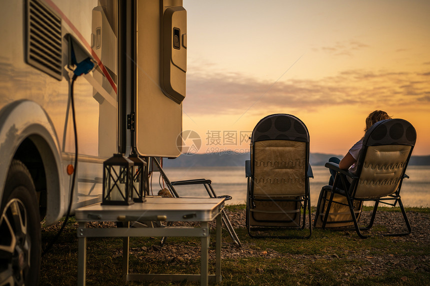 风景秀丽的房车露营地露营车在休闲车公园女人在椅子上放松图片