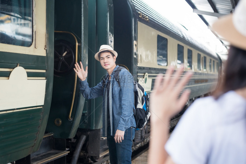英俊的亚洲年轻人在乔恩之前跟火车站图片