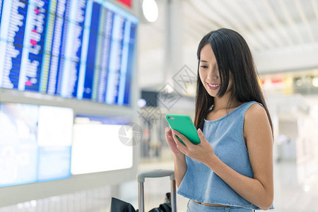 在机场用手机查航班号的女人图片