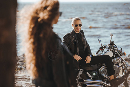 女孩在海边骑着摩托车坐在摩托车上看男友时图片