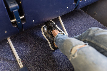 女乘客在长途商业飞机行中伸展双腿出口座位的腿部空间更大图片