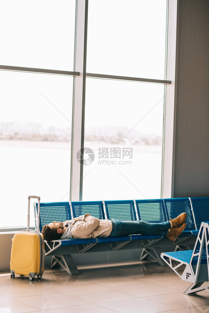 青年男子在机场候机时坐在座位上图片