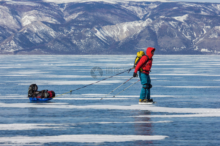 男远足者背包站在冰水表面俄罗图片
