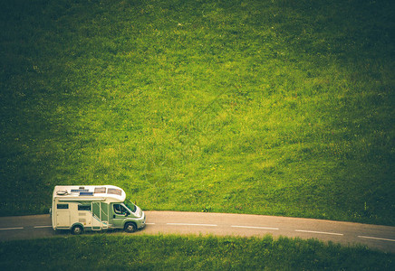 露营者范旅行车在乡边路上的C型越野图片