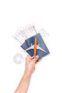 手持护照机票和小飞机型号的白色单方飞背景图片