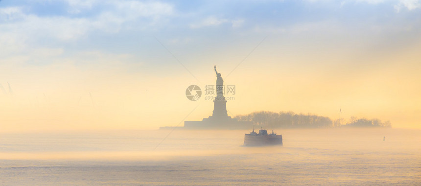 StaternIslandFerry号航行于明暗的日落时经过自由女神像图片