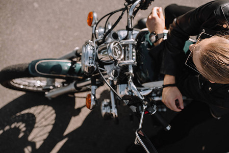 骑自行车的人坐在老式古典摩托车上的俯视图图片