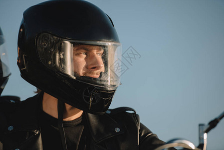 戴着摩托车头盔的男人的肖像望向远方图片