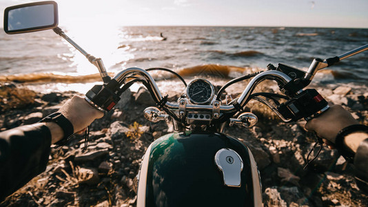 坐在海上经典摩托车上的摩托车驾驶员图片