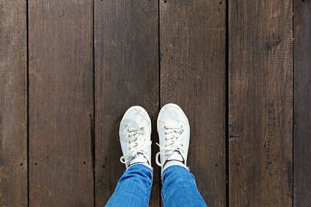 木地板背景的时装运动鞋上的脚自拍图片