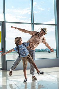 父亲和小儿子在机场等待登机时图片