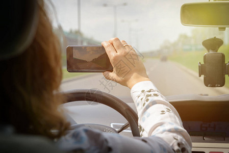 女驾驶汽车时使用智能手机录制视频风险驾驶行为概图片