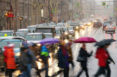 街上正在下雨人们在绿灯下过马路图片