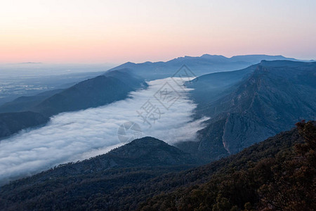 山谷中的云层和日出时的奇幻之地范围从澳大利亚维多利亚格拉姆皮亚州的图片