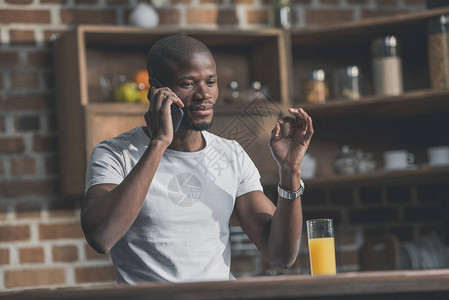 非洲人在厨房讲电话时在图片