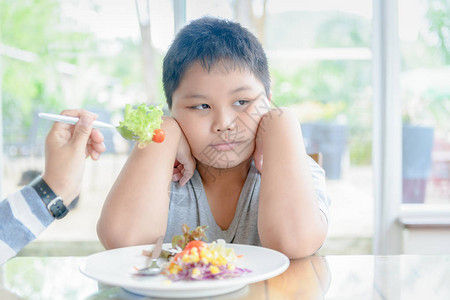 厌食症肥胖的子对蔬菜表示厌恶背景图片