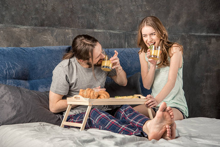 年轻快乐的情侣在床上吃图片