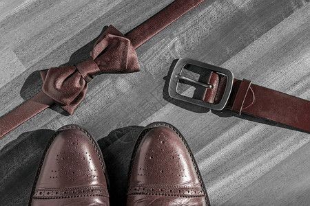 在木灰色地板背景上搭配优雅的棕色皮革男鞋图片
