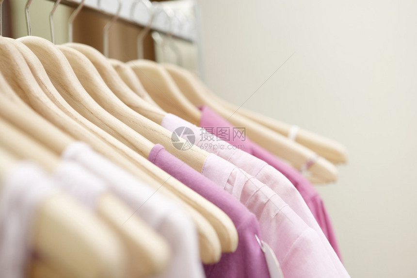 时装店挂在木架上的粉红色服装图片