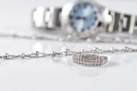 女士手表背景上的银戒指和链子图片