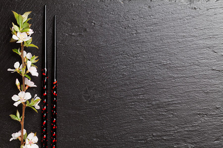 黑石背景的日本寿司筷和樱花图片