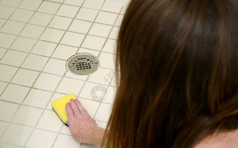 妇女用冲洗板清洗淋浴瓷砖图片
