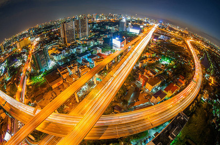 在黄昏时用鱼眼透视在曼谷建设现代商业区的背景中建造了高速公图片