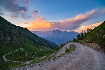 萨尼山口通往意大利高山口的土山路ColledelleFinestre日落时的广阔景色背景