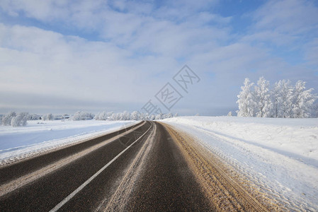 阳光明媚的日子里的乡村冬季公路图片