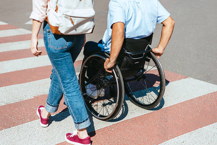 残疾人在轮椅上男友残疾的形象和城市中穿越横行的图片