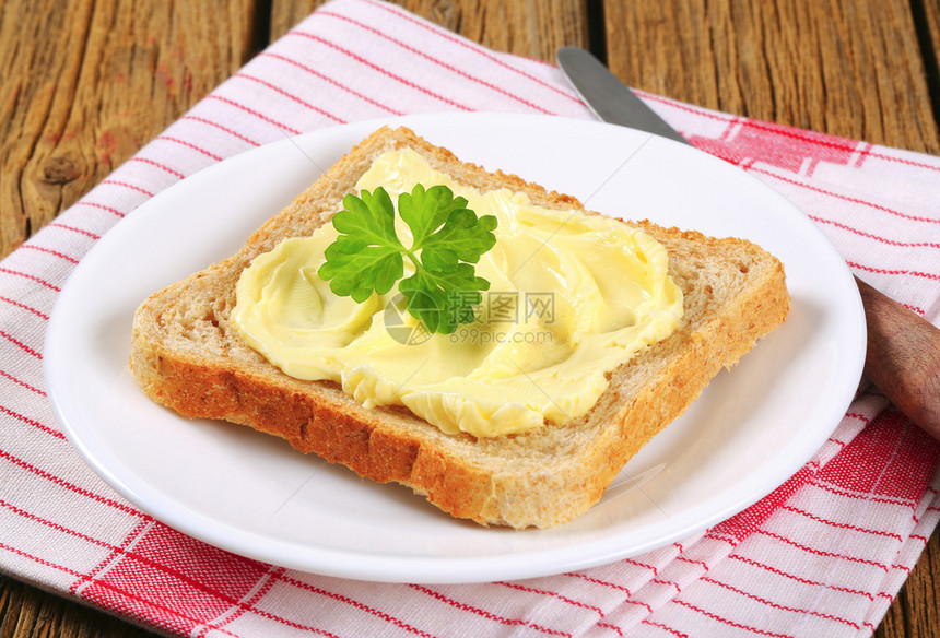 一片全麦三明治面包和黄油图片