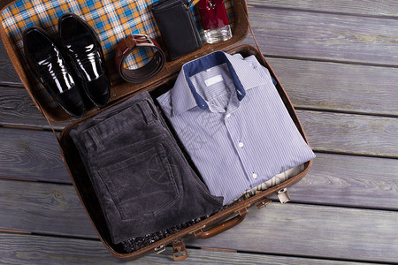 一套时尚的男士服装在旧行李箱里图片
