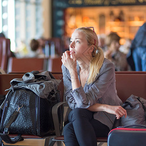 年轻的金发碧眼的卡布西亚女人在机场候机站等候满载过敏者图片