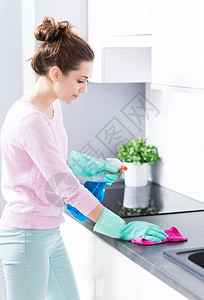 快乐的年轻女人打扫厨房图片