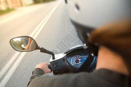 女在空荡的路上骑摩托车摩托踏板车长时间曝光图像高速模拟主观图片