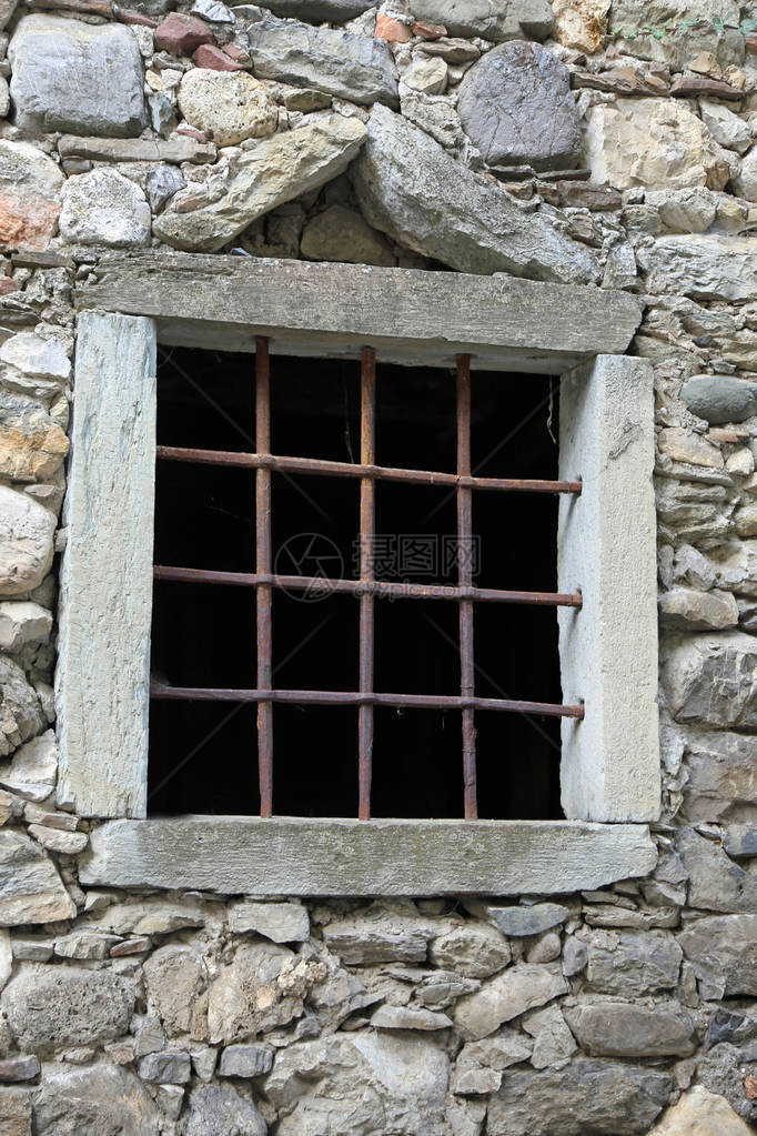 古老农舍马厩的带格栅和石墙的窗户图片