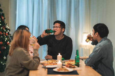 晚上在房子的圣诞树旁提供啤酒和比萨饼食品图片