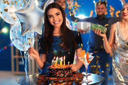 在俱乐部派对的生日蛋糕附近年轻姑娘在她图片