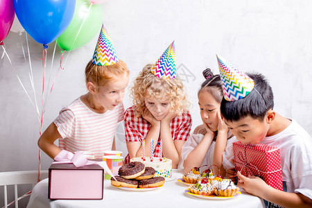 快乐的孩子们准备好尝生日蛋糕图片