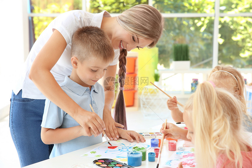 小男孩和老师在教室里上绘画课图片