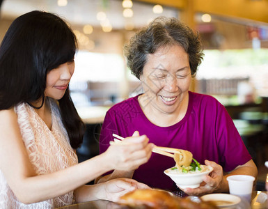 幸福的女儿和年长母亲在餐图片