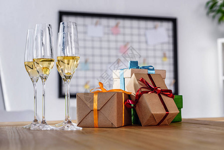 办公室桌上的香槟杯和礼品背景图片