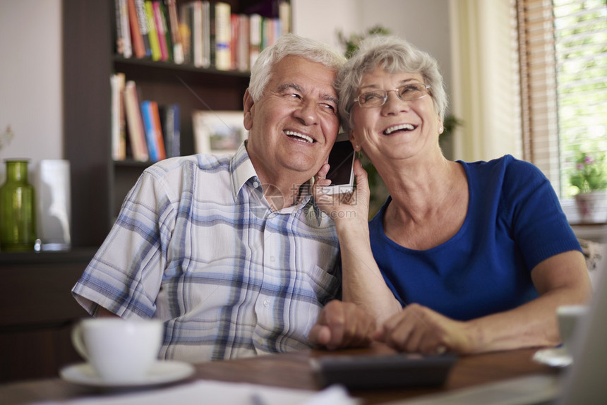 祖父母在餐桌上用手机说话图片