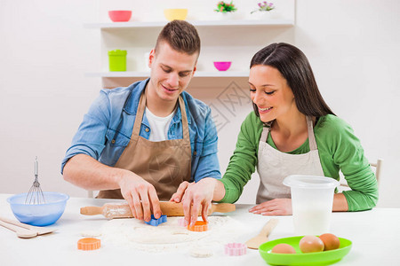 年轻夫妇在他们的厨房做饭图片