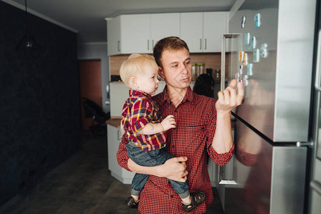 爸和小儿子在厨房冰箱边的厨房里图片