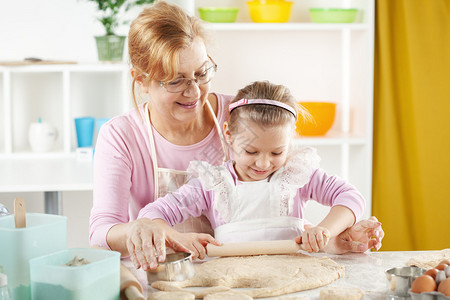 美丽的外婆在厨房把孙女学到烘烤室图片