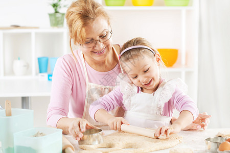 美丽的快乐的祖母和孙女在厨房里一图片
