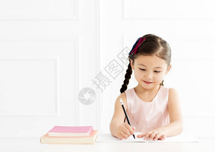 小女孩在家里给笔记本写书图片