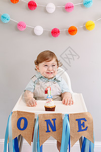 快乐微笑可爱的白种人男婴在家庆祝他的第一个生日图片