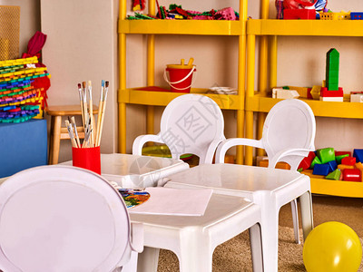 用于玩具的室内装饰货架上的幼儿园桌椅学龄前班等待孩子地板上的彩色气球带白色桌子的游戏室教育儿童创背景图片